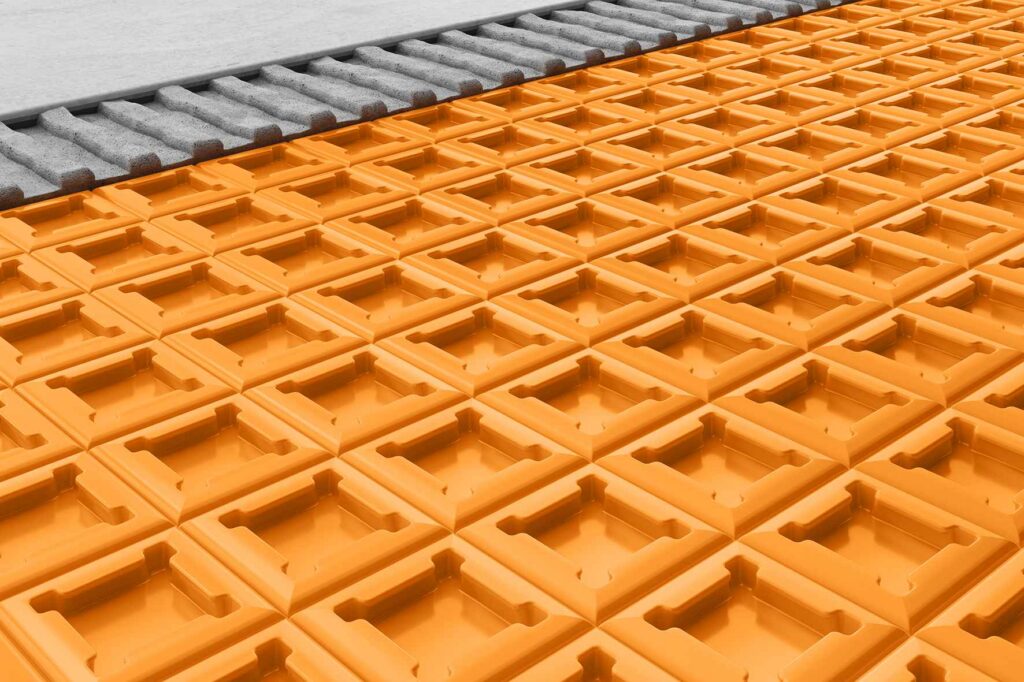 Natte de désolidarisation orange pour carrelage avec structure alvéolée, utilisée pour la préparation et la protection des sols avant la pose du carrelage.