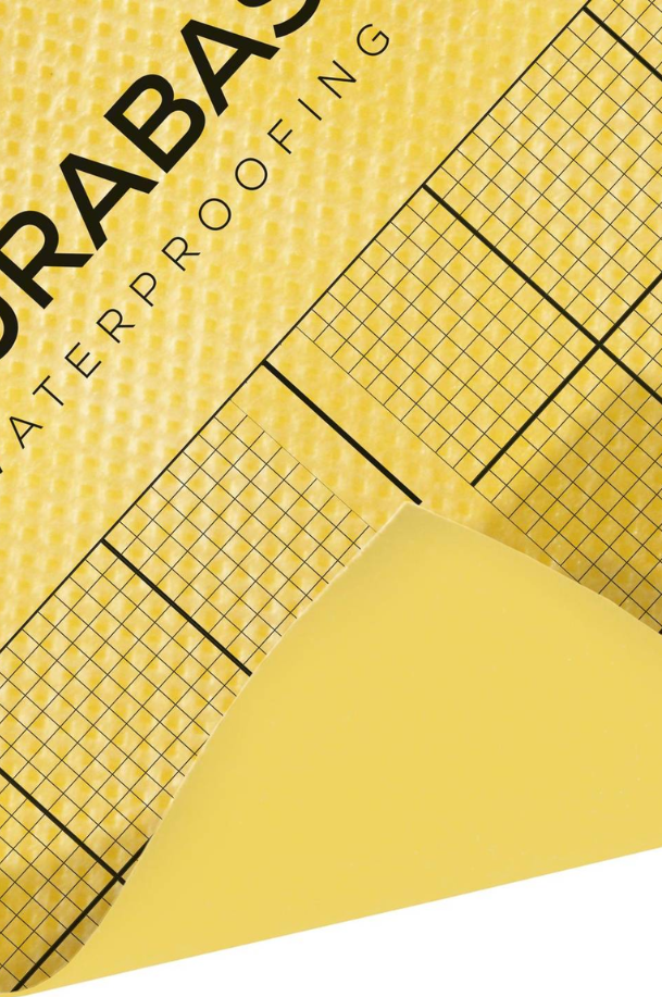 Gros plan sur une natte d’étanchéité DURAL DURABASE jaune avec quadrillage noir pour la pose sous carrelage.